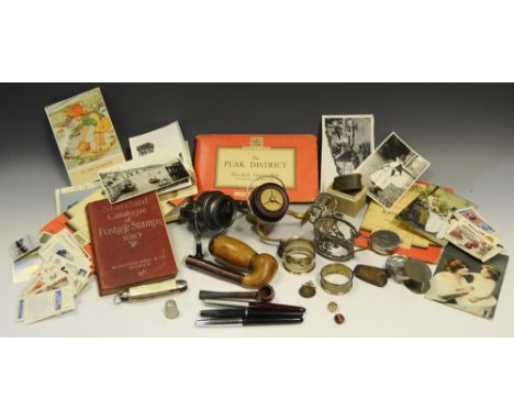 A fishing reel, KP Morritt, pat.no. 798024; another; a pipe; Ordnance Survey maps; postcards; stamps; cigarette cards; pens; 