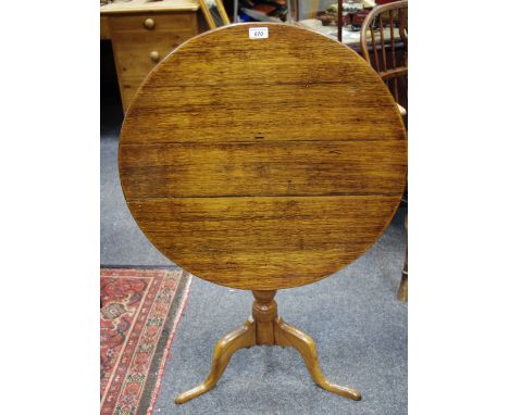 A 19th Century oak and elm tilt top tripod table, column base, pad feet, circular top approx 66cm diameter