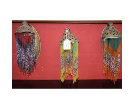 A set of three brass Art Nouveau wall lamps, with beaded shades