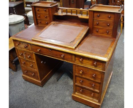A Victorian mahogany pedestal desk, spindle back gallery and shelf, flanked by flights of three drawer Wellington chests, hin