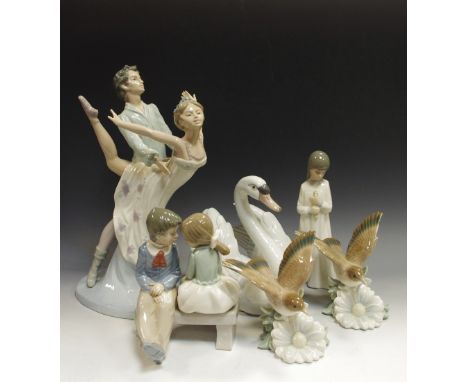 A Lladro model, as a swan; a Lladro figure, of bird hovering over a flower; another, similar; a large Nao figure group, as a 