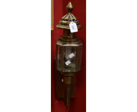 A brass carriage lamp, etched glass panels mounted on an oak wall bracket 