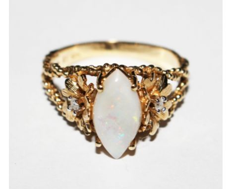 A 10 carat gold ring set with a marquise opal with a single diamond set in a flower head to back shoulder 