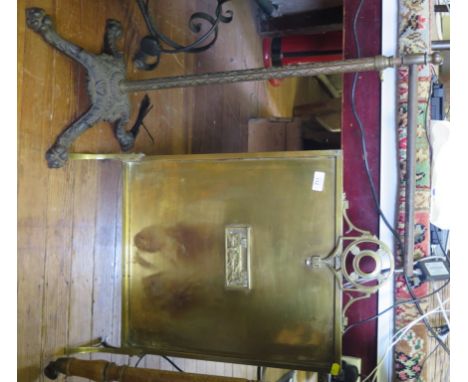 A Victorian cast iron stand with four lion paw feet and a brass firescreen