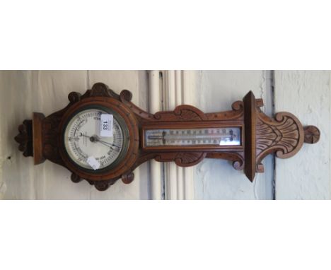 An Edwardian carved walnut banjo barometer, with mercury thermometer and scroll carving, Bruford and Son Eastbourne, 57cm hig