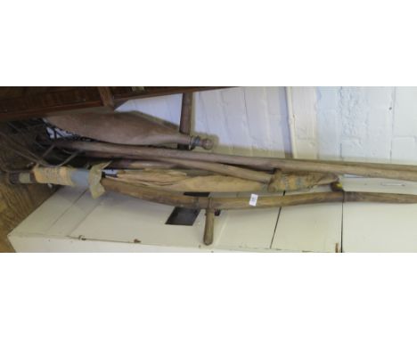 A collection of vintage gardening tools and a yoke