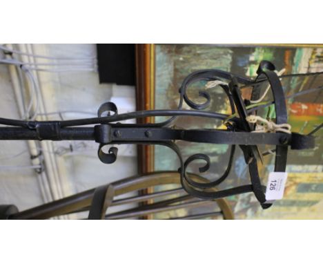 A wrought iron adjustable standard lamp with scrolling tripod base