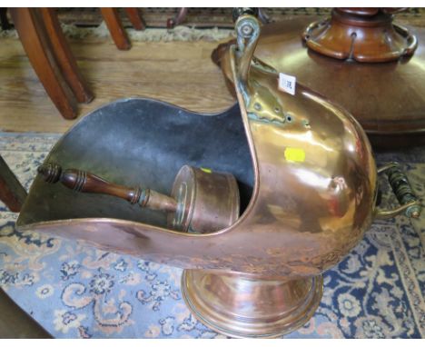 A copper coal helmet with turned ebonised handles and pedestal foot, and a copper shovel (2)