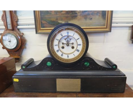 A late Victorian slate mantel clock, the white dial with exposed escapement, on malachite inset scroll supports and plinth ba