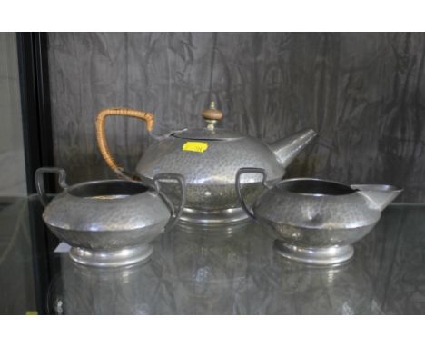 A Tudric hammered pewter teapot, jug and bowl (pattern 1324). (teapot 12cm high)