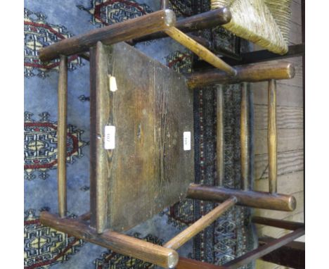 An 18th century turned ash child's armchair, the ladder back with solid seat on turned supports and stretchers 