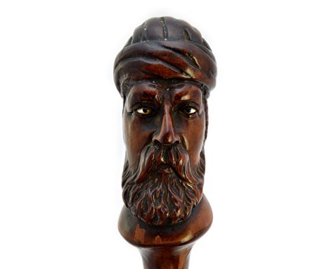 A black thorn walking stick, 19th century, the pommel finely carved with the head of an Arab man, with inset hardstone eyes, 