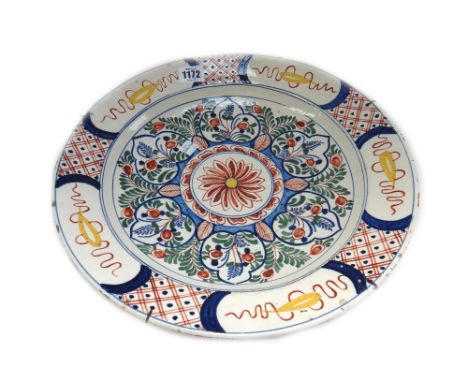 A group of Dutch Delft polychrome wares, 18th/19th century, comprising; a dish painted in the centre with flowers and leaves 