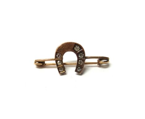 A diamond brooch in a horseshoe design, set with seven cushion shaped diamonds in a pierced beaded surround, gross weight 2.8