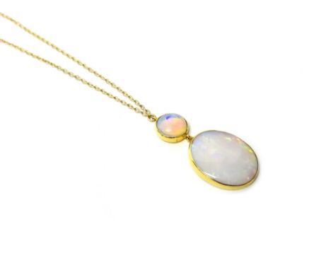 An opal pendant necklace, yellow metal mounted with a circular opal and an oval opal, on an integral neckchain.