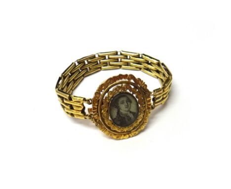 A portrait miniature bracelet, the oval front panel glazed with the portrait miniature of a gentleman, the scroll pierced bor