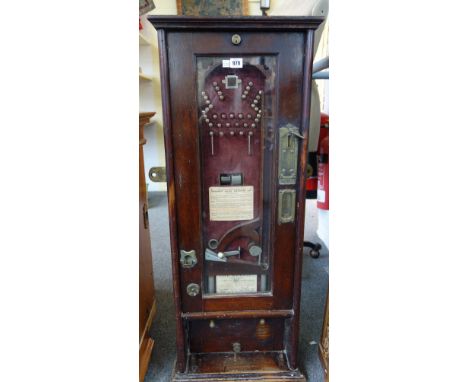 A Cresset penny slot bagatelle wall machine, with an arrangement of metal pins against a red velvet ground, stained oak case 