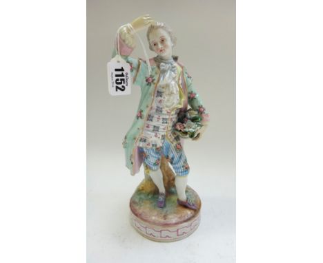 A German porcelain figure modelled as a dandy holding a basket of flowers, standing on a circular base, with painted marks, 2