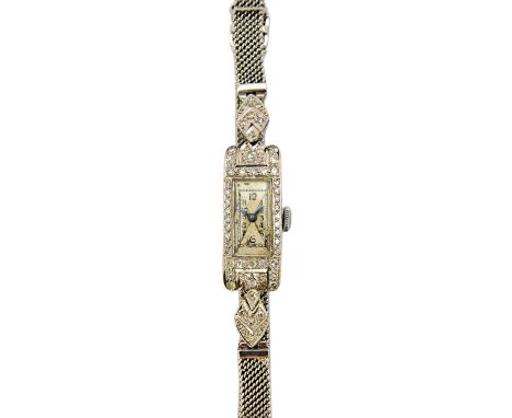 A lady's platinum cased and diamond set rectangular cased dress wristwatch, with a jewelled Swiss movement, the case surround