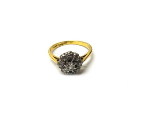 A gold and platinum, diamond set nine stone cluster ring, claw set with the principal cushion shaped diamond at the centre, i