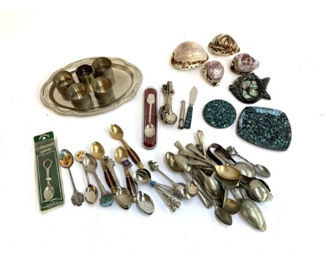 A mixed lot to include a silver plated napkins rings and flatware, souvenir shells, spoons etc 