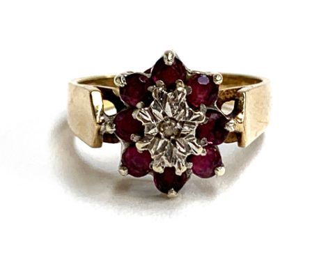 A 9ct gold floral cluster ring set with rubies and an illusion set diamond, size N 1/2, approx. 3.9g