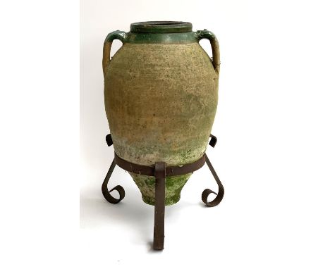A Mediterranean twin handled oil jar, approx. 59cmH set within a wrought iron stand, approx. 66cmH including stand 
