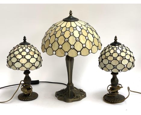 A Tiffany style table lamp, 58cmH; together with a pair of Tiffany style bedside lamps, each 40cmH (3) 