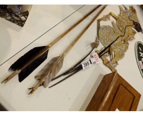 Balinese shadow puppet and two flint headed arrows 