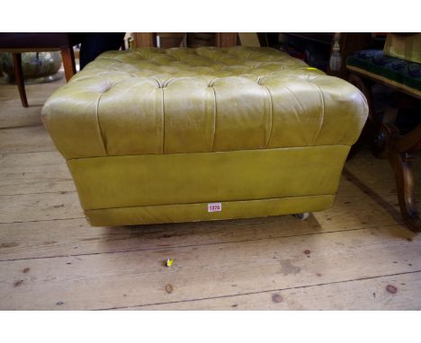 An old buttoned green leather pouffe. 