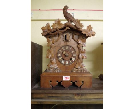 A late 19th century Black Forest carved walnut cuckoo mantel clock,&nbsp;38.5cm high.&nbsp; 