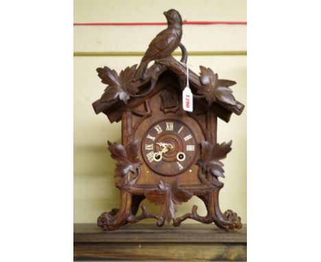 A late 19th century Black Forest carved walnut cuckoo mantel clock, 40.5cm high.&nbsp; 