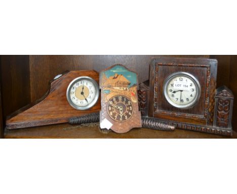 A cuckoo style clock together with two other clocks