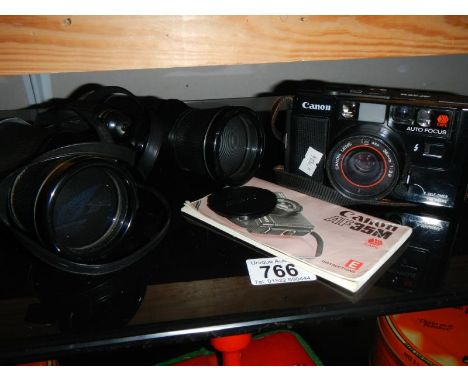 A Canon camera, case, instructions and a pair of binoculars