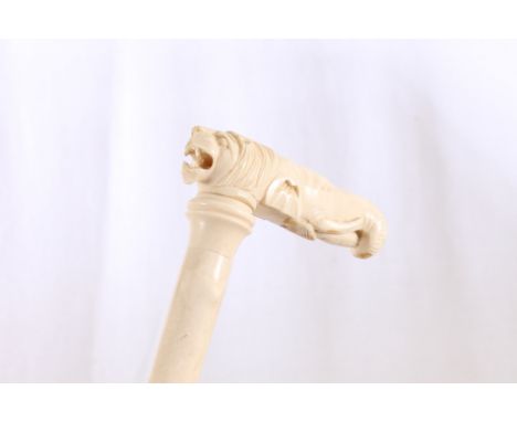 Late 19th century ivory cane, the stick carved with faux bamboo, the grip carved as an elephant and a lion, 76cm