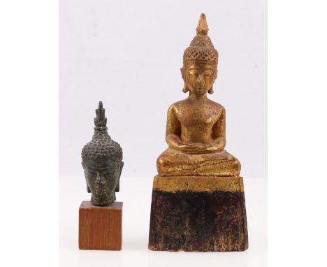 Small bronze Buddha head mounted on a wooden plinth base, 7cm and a carved wooden Buddha, part gold painted, 16.5cm.