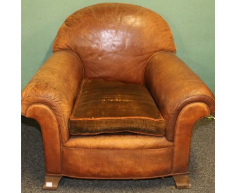 A tan leather club armchair, circa 1930, with scroll arms, on splayed bracket feet, 82cm x 80cm.