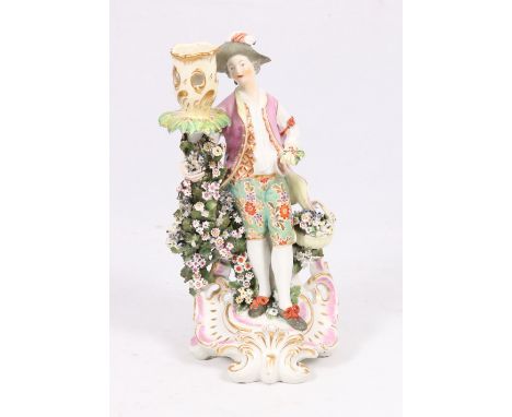 18th century English porcelain candlestick figure of a gardener, possibly Derby, standing on a puce gilt foliate scroll base,