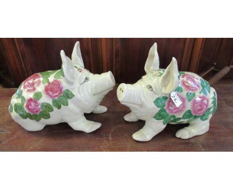 A pair of reproduction Wemyss style ceramic pigs, transfer printed with roses and foliage. Unmarked.(B.P. 21% + VAT) 