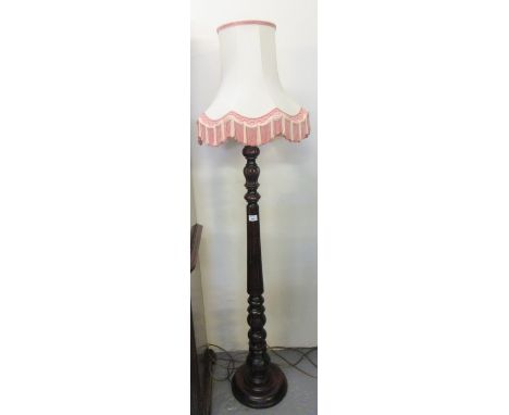 Mahogany turned and fluted standard lamp with tasselled shade, on a circular base. (B.P. 21% + VAT) 