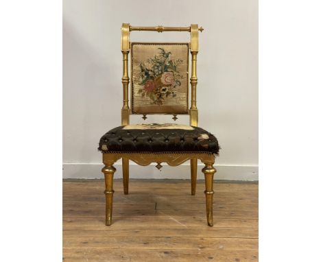 A Victorian giltwood occasional chair, with ring turned crest rail and posts enclosing a back rest upholstered in finely embr