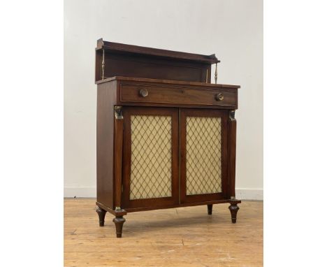A Regency mahogany chiffonier, the raised open shelf back with gallery on turned brass supports, above a projecting frieze fi