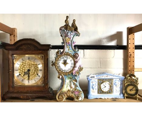 An oak mantle clock, a Capo di Monte mantle clock, H, 49cm, with battery movement and two further clocks