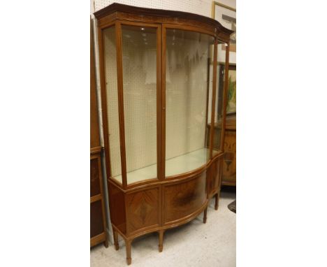 A late Victorian Maples &amp; Co. satinwood serpentine fronted display cabinet with rosewood banding, bears brass "Maples &am