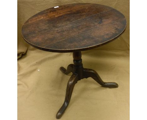 A circa 1800 oak tea table, the circular snap top on a turned pedestal to cabriole tripod base (top with splits)