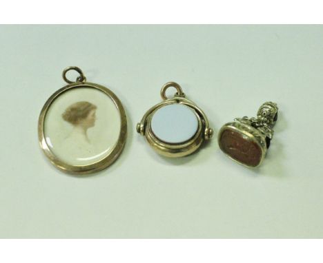 A yellow metal mounted swivel fob seal, another yellow metal mounted Carnelian seal and a yellow metal mounted portrait penda