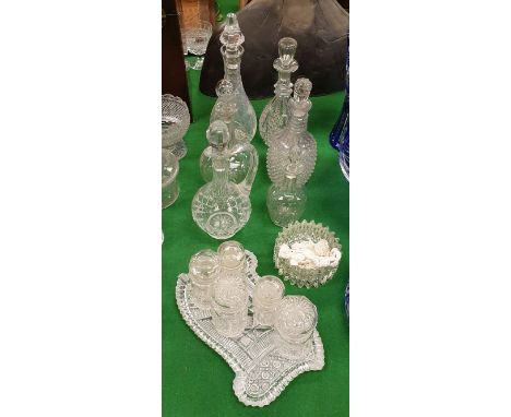 A collection of six various cut glass decanters/ewers, five facet cut jars and covers, pressed glass bowl and a cut glass sha