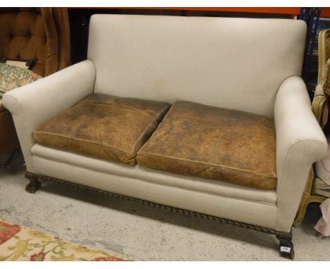 An early 20th Century upholstered two-seat sofa on claw and ball feet in the Georgian style