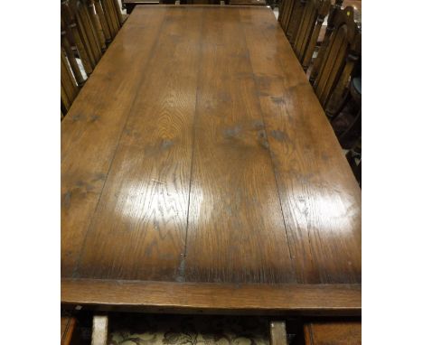 A modern oak refectory style dining table, the plank top above carved frieze to ringed and turned legs united by an H stretch
