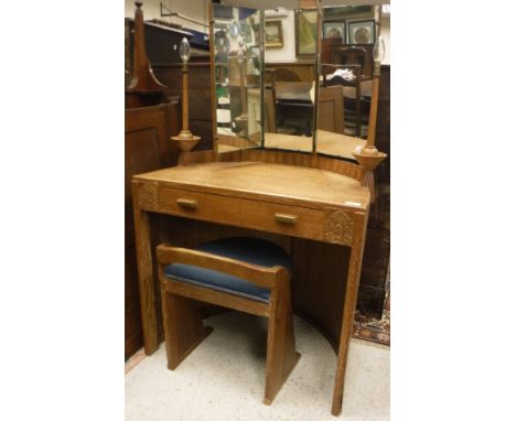 An early 20th Century Arts and Crafts style oak dressing table of small proportions, the triple mirror back flanked by two ri